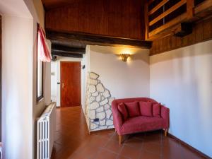 奥尔塔圣朱利奥Apartment Mansarda by Interhome的房间的角落里的一个红色椅子