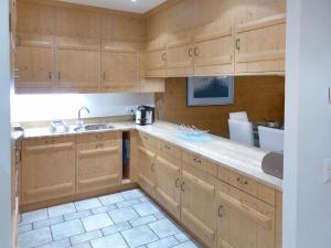 克莱恩 蒙塔纳Apartment Antares by Interhome的一个带木制橱柜和水槽的厨房