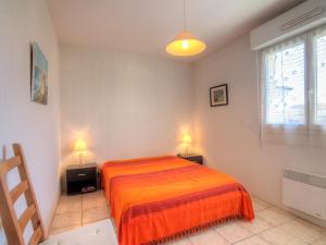 塔尔诺斯Apartment Maria Callas by Interhome的一间卧室配有橙色的床和两盏灯。