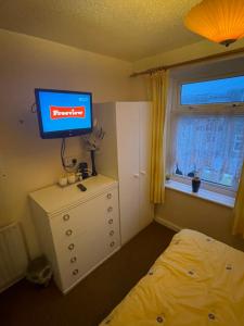 布莱克浦Highbury Hotel的一间卧室配有一张床,梳妆台上配有电视