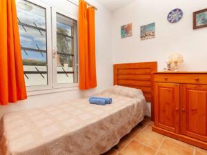 圣马蒂登普里斯Apartment Anfora 1 by Interhome的一间卧室配有床和橙色窗帘的窗户