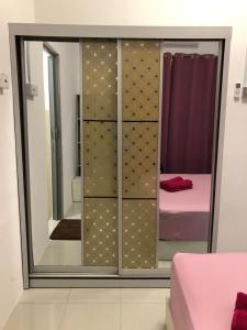 马六甲CASA IDAMAN - Islamic Homez的带镜子的衣柜和床的房间