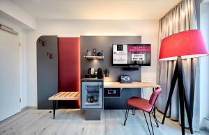 科隆SMARTY Cologne Dom Hotel - Boardinghouse - KONTAKTLOSER SELF CHECK-IN的小厨房配有书桌、桌子和椅子
