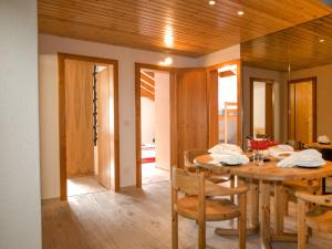 采尔马特Apartment Granit-5 by Interhome的一间带木桌和椅子的用餐室