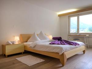 采尔马特Apartment Granit-5 by Interhome的一间卧室配有一张床铺,床上铺有紫色毯子