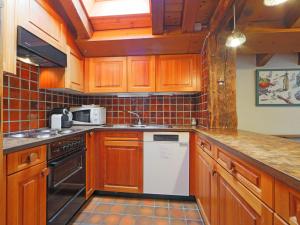 采尔马特Apartment Haus Rollin by Interhome的厨房配有木制橱柜和白色洗碗机。