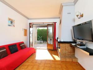 莱斯卡拉Holiday Home La Masia by Interhome的客厅配有红色沙发和平面电视
