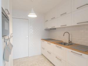 布列登Apartment Residentie Astrid-4 by Interhome的厨房配有白色橱柜和水槽