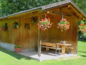 FieschertalApartment Saphir by Interhome的木棚上摆着长凳和鲜花