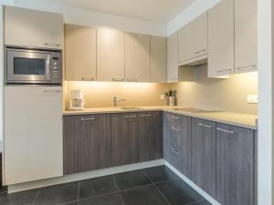 布列登Apartment Residentie Albatros by Interhome的一间带木制橱柜和微波炉的厨房