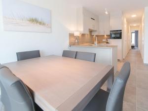 布列登Apartment Residentie Zoë by Interhome的厨房以及带木桌和椅子的用餐室。