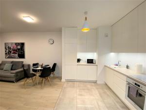 华沙EXCLUSIVE 2BR! Apartment in CENTER +NETFLIX +GYM的厨房以及带沙发和桌子的客厅。