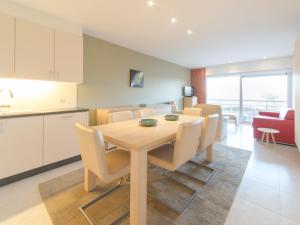 布列登Apartment Seaside 4-02 by Interhome的厨房以及带木桌和椅子的用餐室。