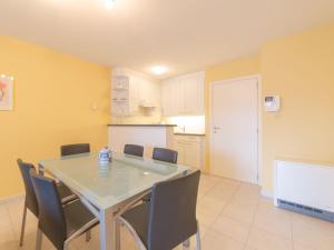 布列登Apartment Residentie Duinenbries-2 by Interhome的厨房以及带桌椅的用餐室。