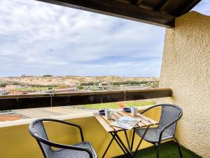 塞尼奥斯Apartment Trinquart-6 by Interhome的阳台享有沙漠美景,配有桌椅。