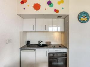 塞尼奥斯Apartment Trinquart-6 by Interhome的厨房配有白色橱柜和水槽