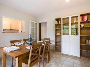 卡布勒通Apartment Tassigny by Interhome的厨房以及带木桌和椅子的用餐室。