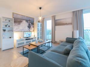 布列登Apartment Residentie sunset by Interhome的客厅配有蓝色的沙发和桌子