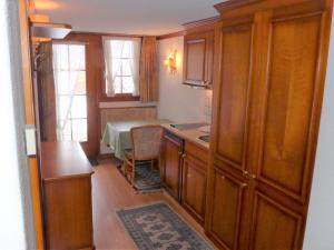 采尔马特Apartment Casa Pia-1 by Interhome的厨房配有木制橱柜和桌子。