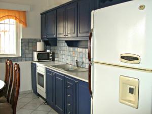 蒙纳斯提拉奇Kristallia Rooms的厨房配有蓝色橱柜和白色冰箱