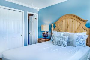 德斯坦4 A, Three Bedroom Townhome的卧室配有白色床和蓝色的墙壁