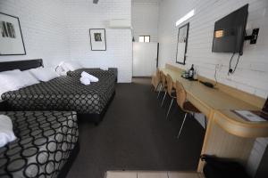 贡迪温迪联排别墅汽车旅馆的一间设有两张床和一张桌子及椅子的房间
