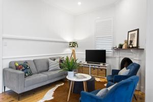 土乌巴Sierra Cottage - A Homely Space, Superb Location的客厅配有沙发和2把蓝色椅子
