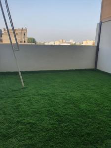 Ma‘ābīlahشاليه الشهد的一间拥有绿色草地和白色墙壁的房间
