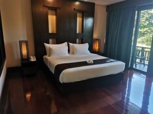 彭世洛尤迪亚传统风格酒店的一间卧室设有一张大床和一个大窗户
