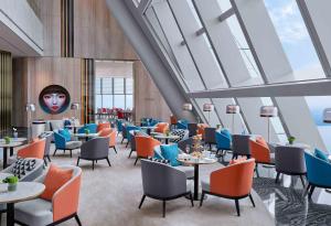 苏州苏州尼依格罗酒店的餐厅设有桌椅和大窗户。