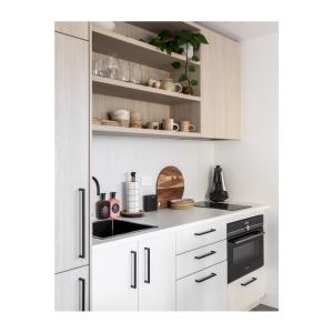 Albion ParkStudio On Park的厨房配有白色橱柜和黑色家电