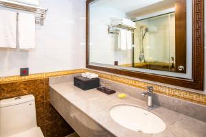 澳门富华酒店的一间带水槽、镜子和卫生间的浴室