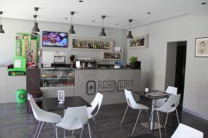 维达古Restaurante e Residencial O Resineiro的一间带2张桌子和白色椅子的餐厅