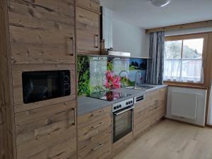 斯拉德明Bauernhof - Appartement beim Zefferer的厨房配有木制橱柜、水槽和微波炉