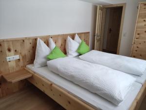 斯拉德明Bauernhof - Appartement beim Zefferer的一张带绿色和白色枕头的床