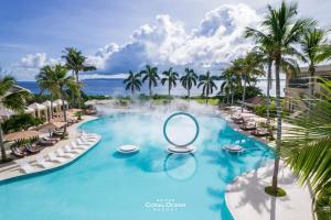 塞班Coral Ocean Resort的棕榈树和镜子度假村的游泳池