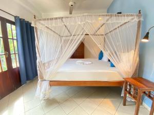 乌纳瓦图纳Unawatuna Nor Lanka Hotel的配有蚊帐的客房内的一张床位