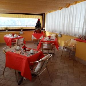 蒙泰罗通多库佩拉住宿加早餐旅馆的餐厅设有桌子、红色桌布和圣诞树