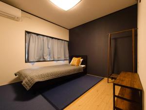 高野山Guest House Suzumeno Kakurembo的一间卧室配有一张带窗户和桌子的床