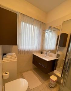 梅拉诺Naif-Home的一间带水槽、卫生间和镜子的浴室