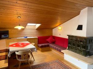 奥蒂塞伊Residence Lastei的客厅配有红色的沙发和桌子