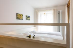米特尔贝格瓦尔顶门格豪恩旅馆的一间白色卧室,床上有两只企鹅