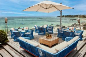 贝尔马尔C Mauritius - All Inclusive的一个带蓝色椅子、桌子和遮阳伞的甲板