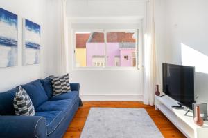 里斯本WHome Hideaway Family Apartment #3的客厅配有蓝色的沙发和电视