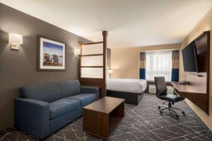 奥罗拉Microtel Inn & Suites by Wyndham Aurora的酒店客房设有一张沙发和一张床