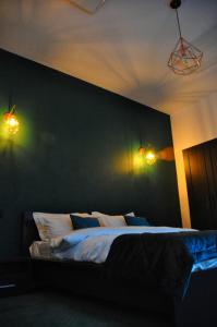 布拉索夫Celebrity Apartment Brasov的卧室配有一张带两盏灯的墙壁床。