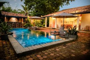 坦加拉Villa Don Bastian的一个带遮阳伞和房子的游泳池