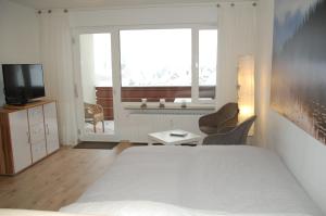 恩茨克勒斯特勒Ferienwohnung mit Aussicht的一间卧室设有一张床、一台电视和一个窗口。