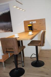 恩茨克勒斯特勒Ferienwohnung mit Aussicht的一张桌子,两把椅子,桌子上还有杯子