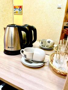 沃罗涅什Hotel Nord的茶几,茶几,咖啡壶,杯子和碟子